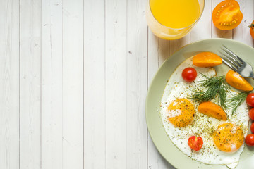 Fried eggs with cherry tomatoes on a plate