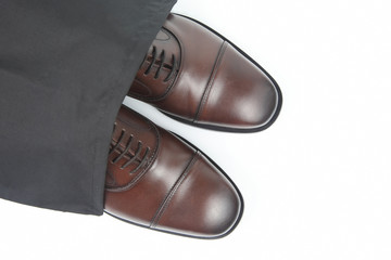 Classic men's brown Oxford shoes in protective black pouch on white background