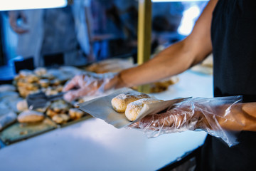 Female Shop Assistant In Bakery Serving Customer