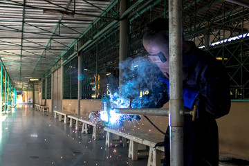 Working person About welder steel Using electric welding machine There are lines of light coming...