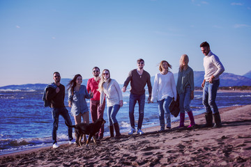 young friends jumping together at autumn beach