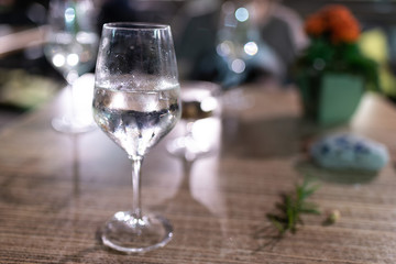 Bicchiere cristallo con gambo a lungo stelo contenente cocktail trasparente