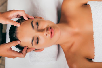 Obraz na płótnie Canvas smiling woman relaxing in massage salon