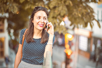 Junge Frau telefoniert unterwegs mit dem Handy