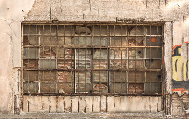 Old metal glass squared industrial window, blacked with red bricks from inside.