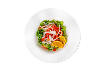 Salad with seafood with squid, tomato, bell pepper, fish, salmon, lettuce and orange, citrus on plate, white isolated background, view from above, for the menu, restaurant, bar cafe