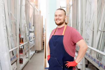Smiling bearded white salesman in construction superstore offers siding