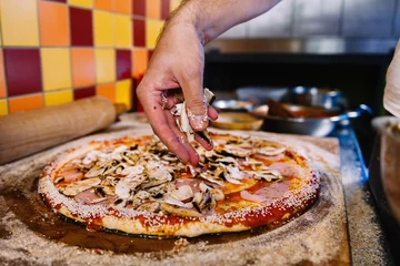 Foto op Plexiglas Paddestoelen op pizza zetten in pizzarestaurant © Microgen
