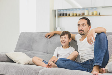 Father and son watching TV at home