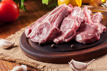 Raw fresh lamb chops on wooden cutting board