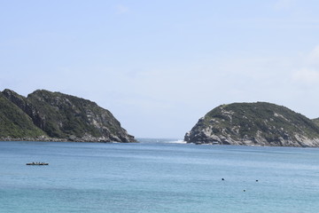 Fototapeta na wymiar Fenda entre colina verde em mar azul turquesa. Arraial do Cabo