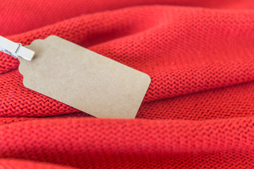 Blank tag on a terracotta sweater, autumn concept with space for the text