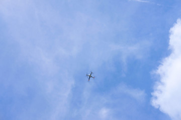 Drone hovers amidst a blue sky