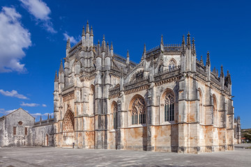 Fototapeta na wymiar Batalha, Portugal. Monastery of Batalha aka Santa Maria da Vitoria Abbey. Facade with Portal in Gothic and Manuelino aka Manueline style