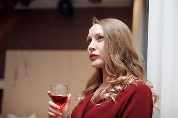 Attractive blond woman with a glass of red wine