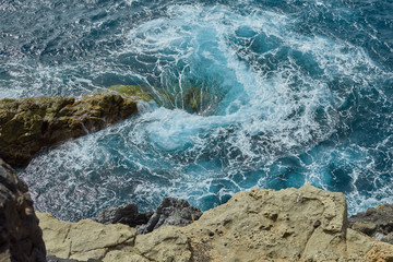 Natural swirl with foam in the sea of ​​the village of Ajuy seen from the top of the rock formation ravine in Fuerteventura, Canary Islands, Spain
