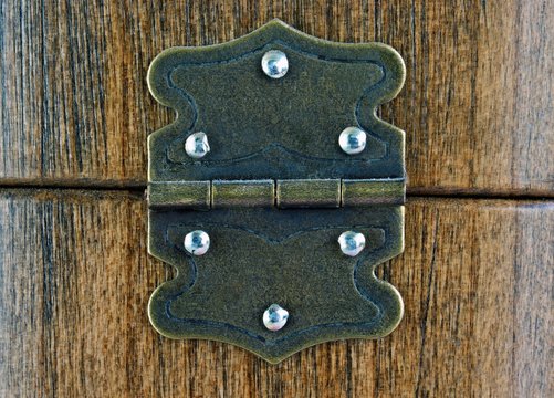 Old dusty rustic hinge on wooden box background 