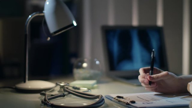 Medical treatment. Doctor hand write x-ray images results. Specialist examing roentgen. Medical xray diagnostic. Female hand write lungs xray result at doctor reception