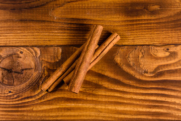 Brown cinnamon sticks on a wooden table. Top view
