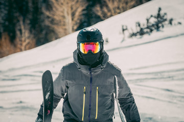 Fototapeta na wymiar Masked Skier On The Side Of A Resort Mountain
