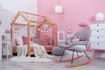 Child's room interior with comfortable bed and garland