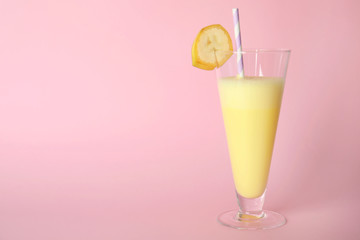 Glass of tasty milk shake and space for text on color background
