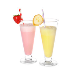 Glasses of tasty milk shakes on white background