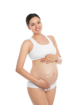 Pregnant woman with smile painted on her belly against white background. Body cream