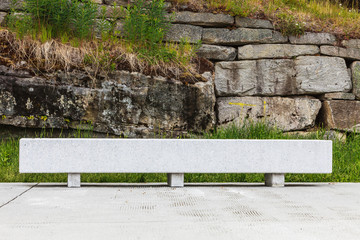 Small concrete wall bench by rock cliff