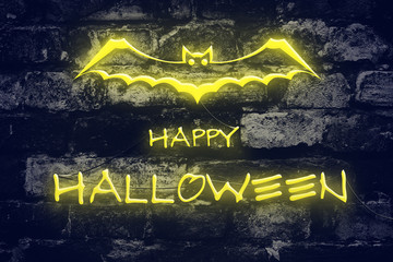 Neon inscription Happy Halloween on the background of an old brick wall. Holidays