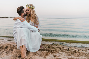 Fototapeta na wymiar affectionate bride and groom going to kiss on beach