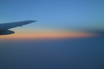 Breathtaking color layer of sunrise sky with airplane wing view from the plane window 