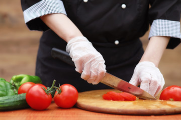 The cook cuts fresh farm vegetables