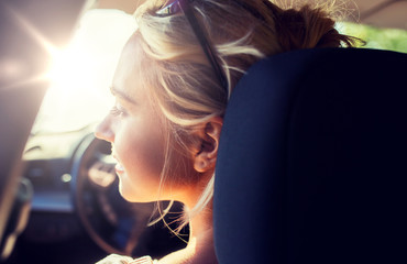 summer vacation, holidays, travel, road trip and people concept - happy teenage girl or young woman in car