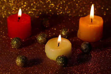 Burning candles with the glitter bokeh in the background.