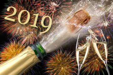 Champagnerflasche mit poppendem Korken und Sektgläser beim Anstossen vor Brillantfeuerwerk zu...