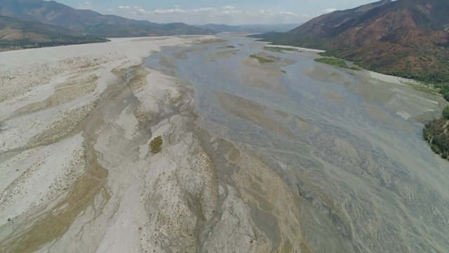 Parched river in mountain province Luzon, Philippines. Aerial view Drought in mountain valley, dry and shallow Bucao river.