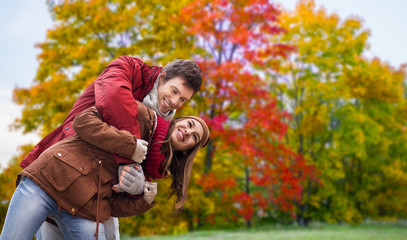 love, relationship and season concept - happy teenage couple hugging over autumn park background