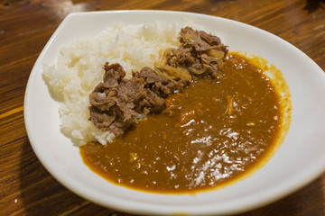 Japanese curry with rice topped with beef and onion simmered in a mildly sweet sauce flavored 