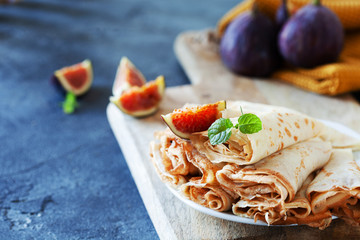 Homemade golden crepes with fresh figs on the plate