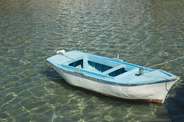 Pserimos port, boat on the blue water.