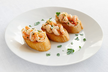 fried bruschetta slices with fried in garlic oil scampi decorated with parsley