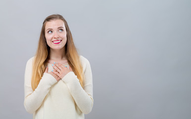 Woman with heartfelt expression on a gray background