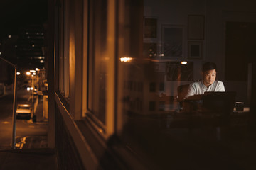 Asian businessman working late in the city at night 