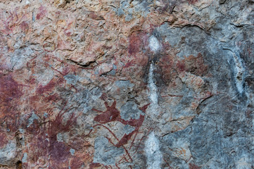 Color prints on the cliff walls, which are ancient prints of people in the past, by this image located In the tourist attractions of Thailand.