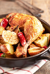 Oven-baked chicken with vegetables and fresh herbs. Homemade food. Symbolic image. Concept for a tasty and hearty dish. Rustic wooden background. 