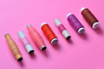 pink thread reels for sewing on a pink background. photo thread on. threads of shades of pink....