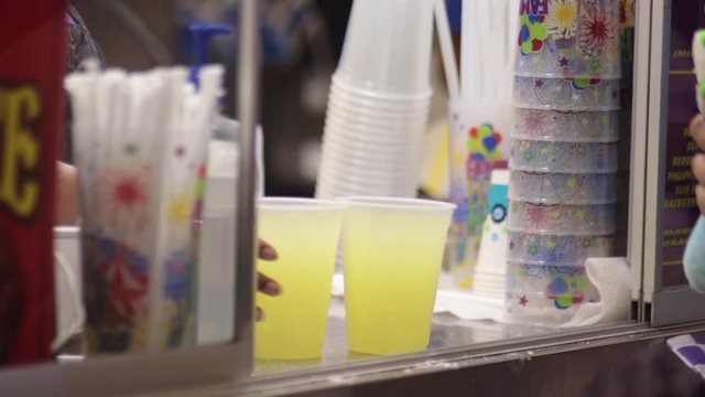 Person being served lemonaid out of carnival cart editorial
