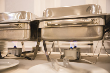 Metallic shiny trays are heated on gas burners