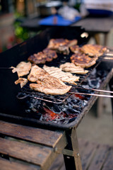 A hot grill full of barbecued meats.